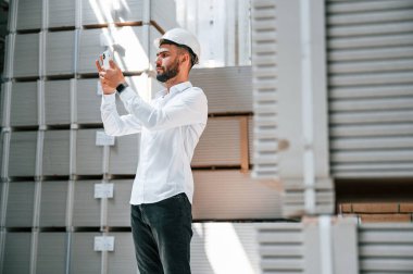 Telefonla. Depo işçisi depoda bir sürü ürünle birlikte..