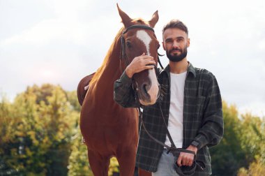 Günlük kıyafetlerle. Atlı genç adam dışarıda..