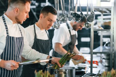 Belgelere bakıyorum. Mutfak işçileri birlikte yemekleri hazırlıyorlar..