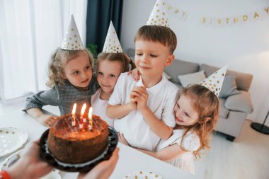 Doğum gününü kutluyoruz. Pasta tutan kadın. Bir grup çocuk gündüzleri evde birlikteler..