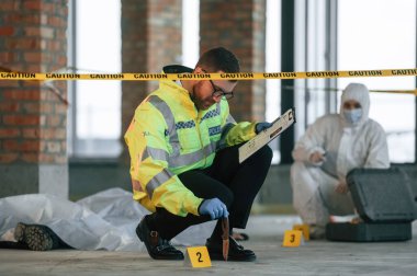 Bıçak izi. Dedektifler cesedin yanındaki suç mahallinde kanıt topluyorlar. Adli tıp uzmanları uzmanlık yapıyor..