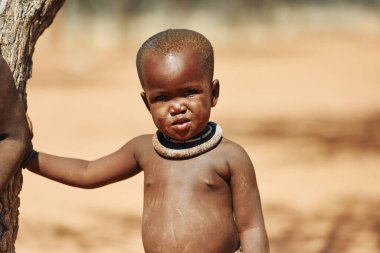 Namibya, Afrika - 14 Haziran 2021: Afrika 'daki etnik insanların çocuğu açık havada. Ön görünüm.