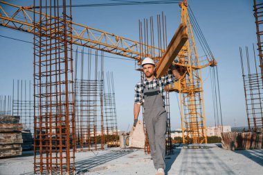 Crane arkada. Tahta bir parça tutuyorum. Gündüz vakti inşaatta çalışan bir adam var..
