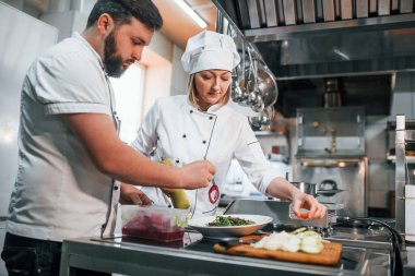 Üç kişi. Vejetaryen salatası. Profesyonel aşçı mutfakta yemek hazırlıyor..