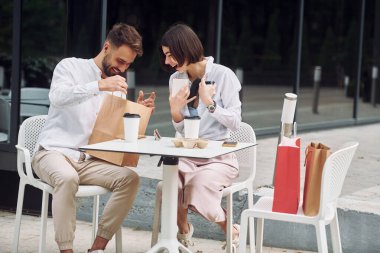 Sandalyelere oturup alışverişe bakmak. Güzel bir çift gün içinde dışarıda alışveriş yapar..