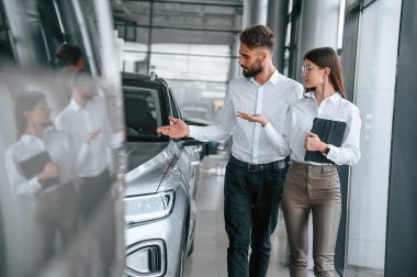 İş görüşmesi yapıyorduk. Beyaz elbiseli bir adam araba galerisinde birlikte..