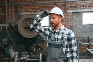 Gri üniformalı ve beyaz şapkalı. Fabrika erkek işçisi içeride..