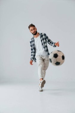 Futbol oynuyordum. Yakışıklı adam stüdyoda beyaz arka plana karşı..