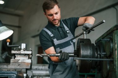 El işi ayrıntıları. Üniformalı adam iş yerinde tarım tekniğinin detaylarını geliştiriyor..