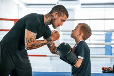 Tavsiye veriyorum. Koç çocuklara kapalı alanda boks teknikleri öğretiyor..