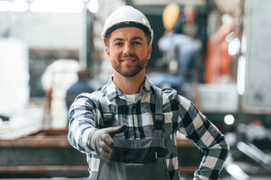 Yardım eli uzatıyorum. Üniformalı fabrika çalışanı içeride..