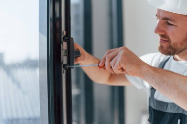 Pencerelerdeki aletleri kullanarak. Tamirci modern odada kapalı alanda çalışıyor..