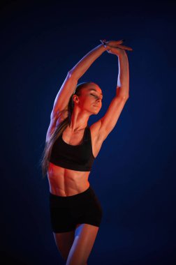 Ellerini uzat. Güzel kaslı kadın stüdyoda neon ışıklı..