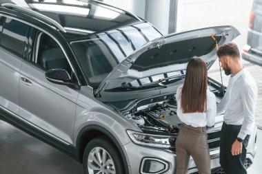 Kaputun altında ne var? Beyaz elbiseli bir adam araba galerisinde birlikte..