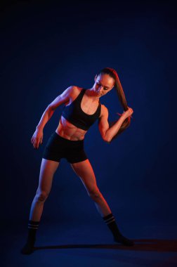 Stüdyoda, kırmızı ve mavi ışıklı. Güzel kaslı kadın içeride..