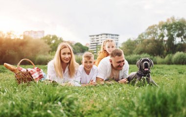 Köpekle birlikte yere uzanmak. Aile yazın birlikte hafta sonlarını dışarıda geçirir..