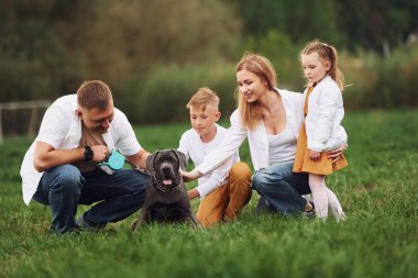 Köpekle birlikte yerde oturuyor. Aile yazın birlikte hafta sonlarını dışarıda geçirir..