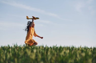 Oyuncak uçakla koşuyor. Mutlu kız yazın dışarıda gezintiye çıkar..