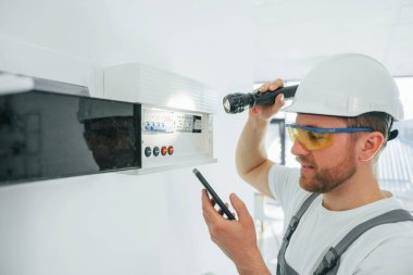 Elektrik sorunları var. Tamirci modern odada kapalı alanda çalışıyor..