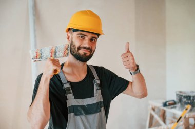 Boya rulosuyla. Adam dairede tamirat yapıyor..