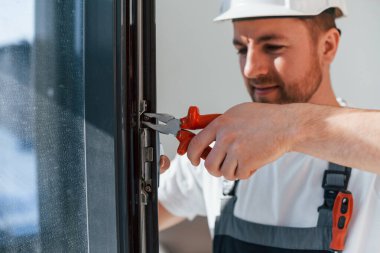 Pencerelerdeki aletleri kullanarak. Tamirci modern odada kapalı alanda çalışıyor..