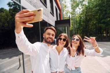 Selfie çekiyorum. Üç arkadaş dışarıda harika bir hafta sonu geçiriyorlar..