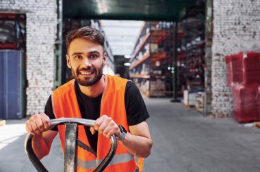 Tramvay platformunda. Depo işçisi depoda bir sürü ürünle birlikte..