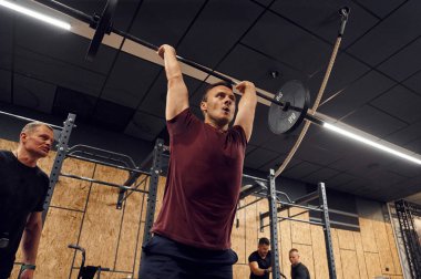 Elleriniz için alıştırma yapın. Güçlü adam spor salonunda halteri kaldırıyor..