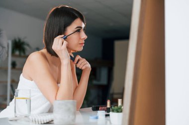 Kirpik makyajı yapıyorum. Genç bayan evde. Güzellik kavramı.