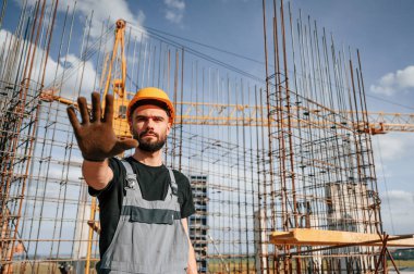Kapalı alan. Kes jesti. Üniformalı adam inşaat alanında çalışıyor..