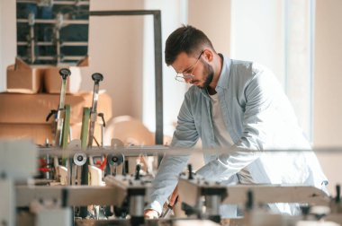 Modern baskı makinesi. Beyaz elbiseli tipografi işçisi içeride..