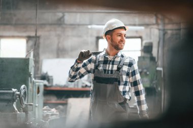 Kasketli. Üniformalı fabrika çalışanı içeride..