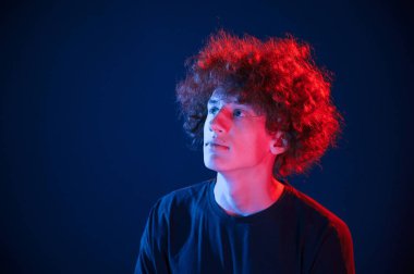 Yukarı bakıyorum. Kıvırcık saçlı genç adam kapalı alanda neon ışıkla aydınlatılır..