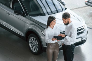 İş görüşmesi yapıyorduk. Beyaz elbiseli bir adam araba galerisinde birlikte..