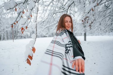 Güzel genç bir kadın kış ormanında dışarıda..