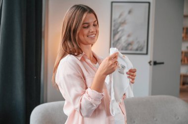 Şirin bir gömlek. Güzel hamile kadın evde..