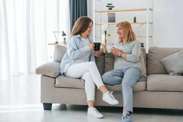 stock image With cup of drinks, having a conversation. Mother and daughter is together at home.