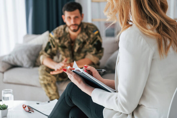 Talking to doctor. Soldier have therapy session with psychologist indoors.