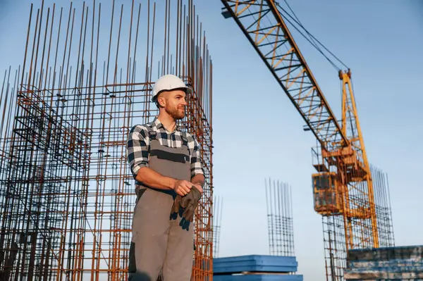 Eldiven takıyordu. Gündüz vakti inşaatta çalışan bir adam var..