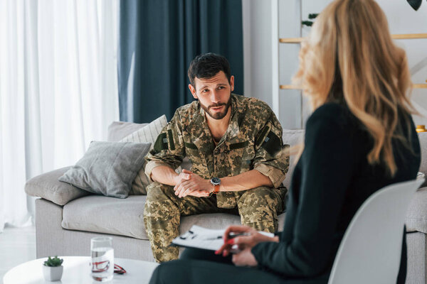Soldier have therapy session with psychologist indoors.