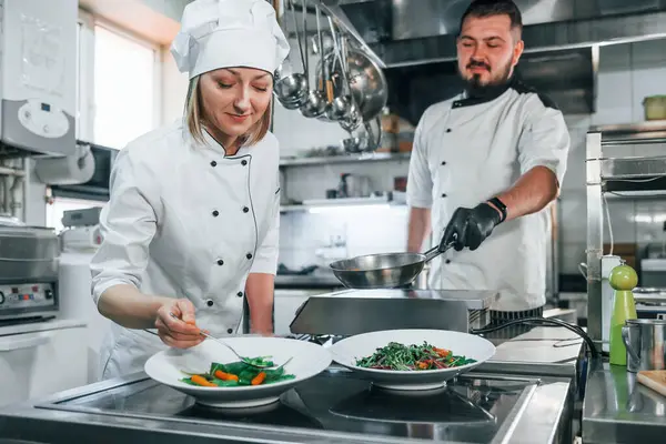 Birlikte çalışmak. Profesyonel aşçı mutfakta yemek hazırlıyor..
