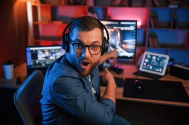 Adam bilgisayarında nişancı oyunu oynuyor. Neon ışıkları.