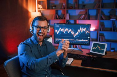 Alkışlar, başarı anlayışı. Hisse senedi tüccarı kapalı alanda bilgisayar başında çalışıyor. Değişim ve para kavramı.