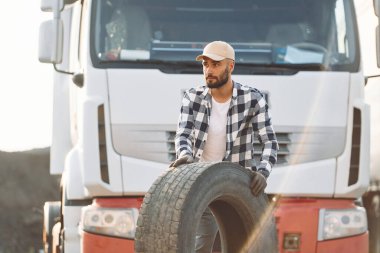 Hasarlı lastikle çalışıyorum. Genç kamyon şoförü gündüz vakti aracıyla geliyor..