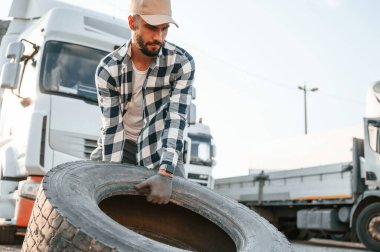 Kırık lastikle. Genç kamyon şoförü gündüz vakti aracıyla geliyor..