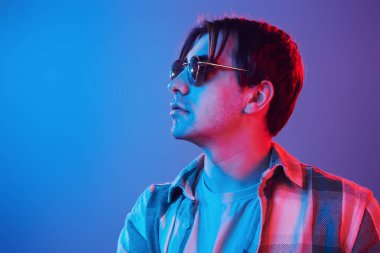 Stylish look. Man standing in the studio with neon light.