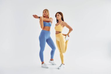 Fitness egzersizleri için hazırlanıyorum. Spor elbiseli güzel kadınlar stüdyoda..