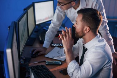 Resmi kıyafetlerle. Ofiste değişim teknolojisiyle çalışan iki borsacı..