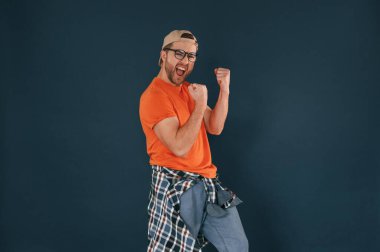 Yakışıklı adam stüdyoda mavi arka planda. Başarı kutlaması.