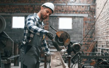 İşletim makinesiyle çalışıyor. Üniformalı fabrika işçisi içeride..